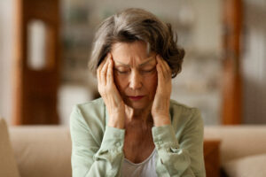 Stressed elderly woman with chronic stress feeling strong painful headache, touching and massaging temples with closed eyes. Migraine, high blood pressure 